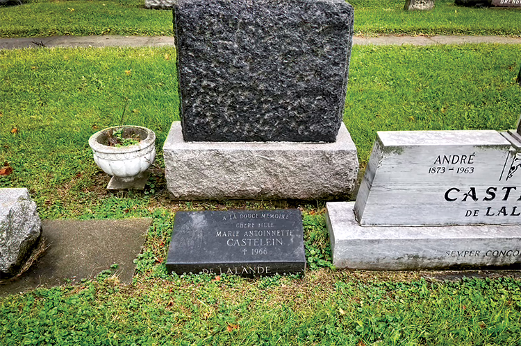 Photo actuelle de la pierre tombale, foncée, de Manette. On aperçoit celle de ses parents à sa droite.