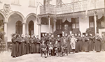 Photo en noir et blanc d’un groupe d’élèves et d’enseignants religieux dans la cour intérieure du Collège Saint-Michel de Bruxelles en 1892.