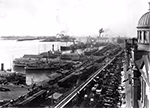 Photo en noir et blanc du port de Montréal vers 1900, prise depuis la chapelle Notre-Dame-de-Bon-Secours, montrant des bateaux et des voitures.