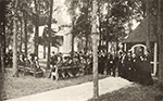 Photo ancienne d'un groupe d'hommes en costumes devant une église, lors des fêtes du conventum du Collège de Saint-Césaire en 1904.