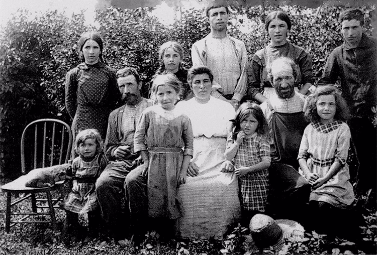 Photo en noir et blanc d’une famille, à l’extérieur, après une journée de travail.