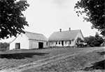 Ferme traditionnelle à West Dover (Vermont) en 1911, composée d’une maison en bois avec véranda et d’une grange attenante, entourée d’arbres et d’une pelouse.