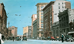 Photo ancienne, colorisée, de Main Street, à Winnipeg vers 1928, avec des piétons et des voitures circulant.