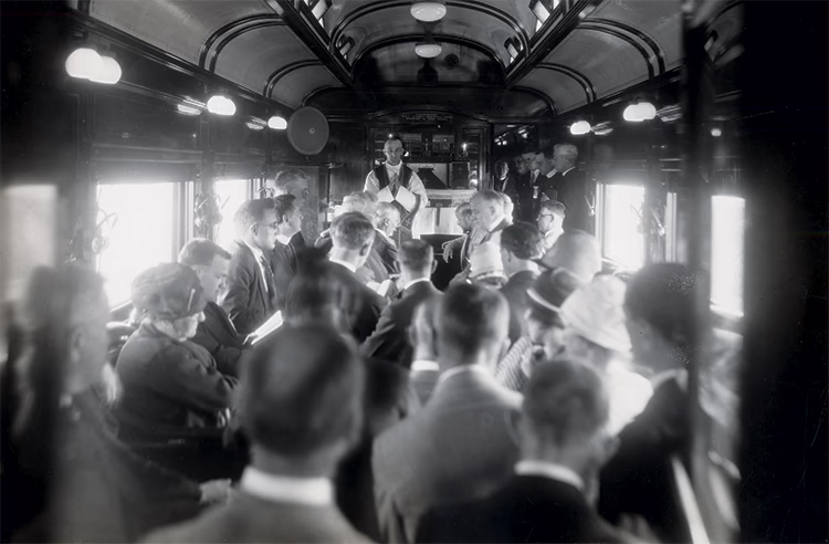 Photo en noir et blanc de passagers dans un train, dans le wagon faisant office de chapelle, Chemin de fer Canadian National Railway, vers 1930.
