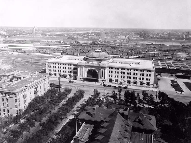 Photo en noir et blanc d'une gare à Winnipeg en 1920, montrant l'architecture et l'activité ferroviaire de l'époque.