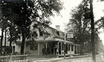 Photo ancienne de l'Hôtel Saint-Denis à Saint-Denis vers 1910, avec des personnes debout devant la maison.